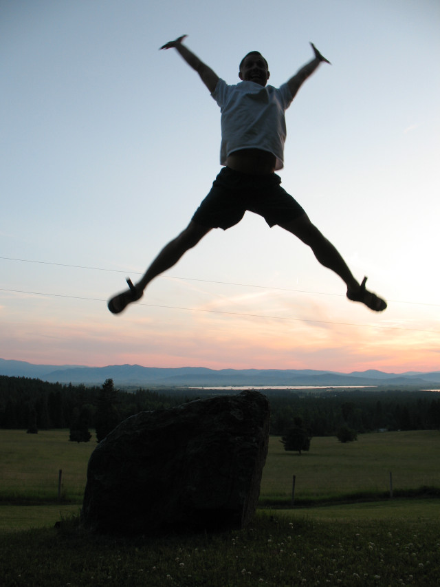 Man jumping sunset rock hands free wallpaper - medium preview image