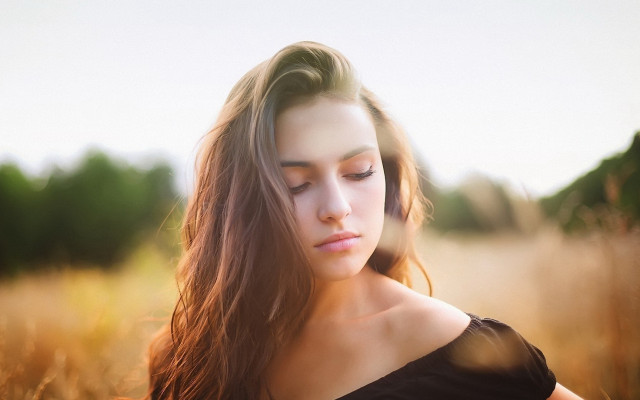 Woman in field blowing hair free wallpaper - medium preview image