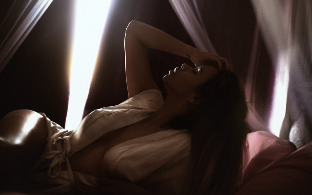 Woman lying bed blowing hair free wallpaper - medium preview image