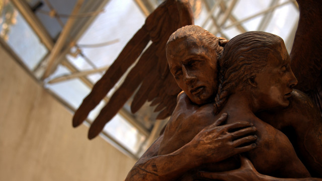 Bronze statue hugging woman wings free wallpaper - medium preview image