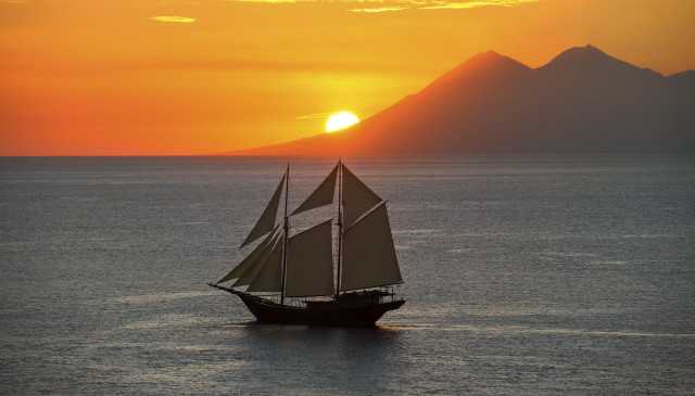 Sailboat ocean sunset mountains clouds free wallpaper - medium preview image
