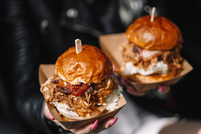 Person holding two pulledpork sandwiches free wallpaper - medium preview image