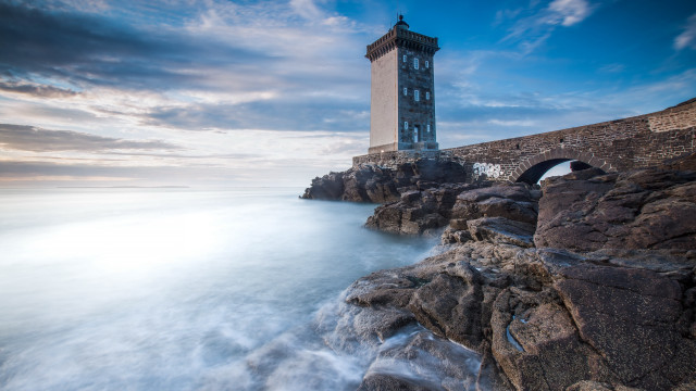 Lighthouse rocky shore bridge clouds free wallpaper - medium preview image