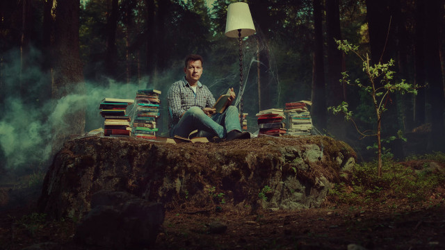 Man sitting pile books woods free wallpaper - medium preview image