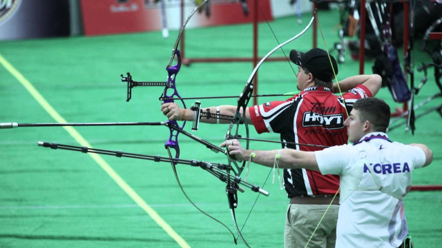 Man holding bow aiming another free wallpaper - medium preview image