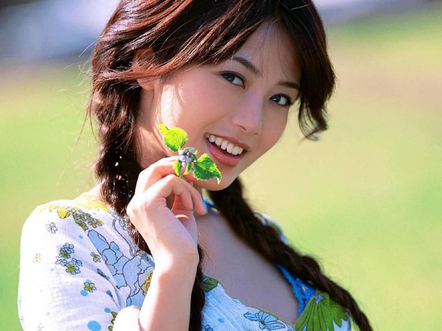 Woman holding leaf smiling green free wallpaper - medium preview image