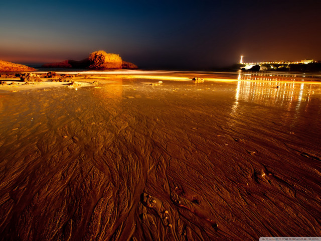 Beach night people lighthouse distance free wallpaper - medium preview image
