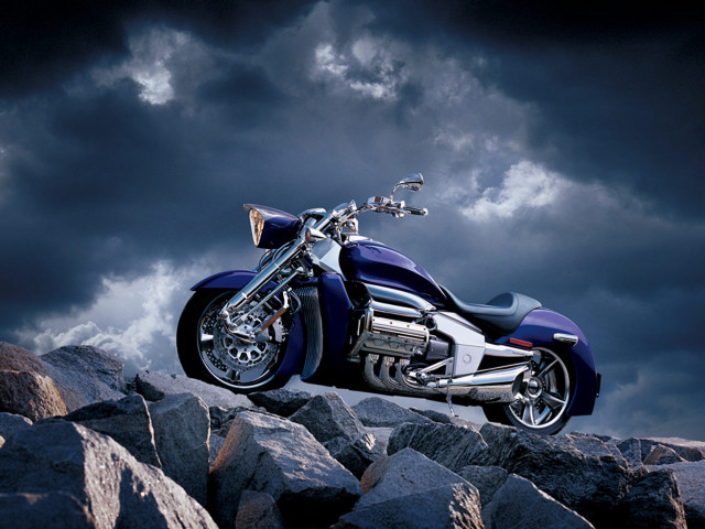 Motorcycle parked rocky hill cloudy free wallpaper - medium preview image