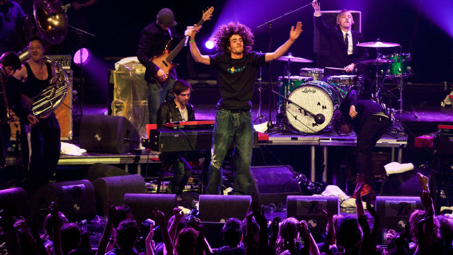 Man standing stage arms raised free wallpaper - medium preview image