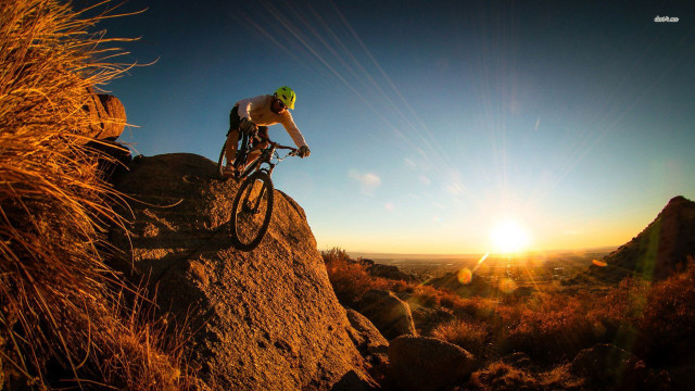 Man riding bike rocky hillside free wallpaper - medium preview image