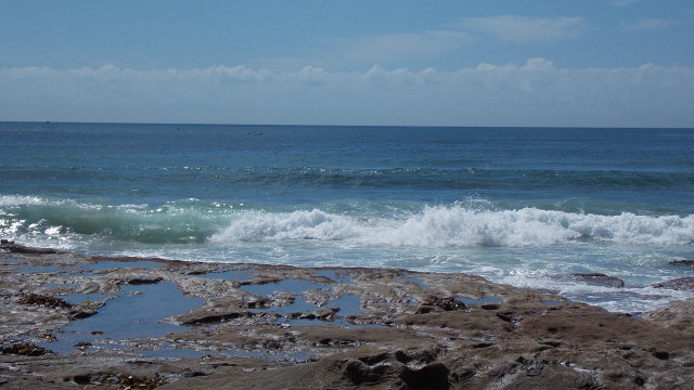 Person standing rocky beach surfboard free wallpaper - medium preview image