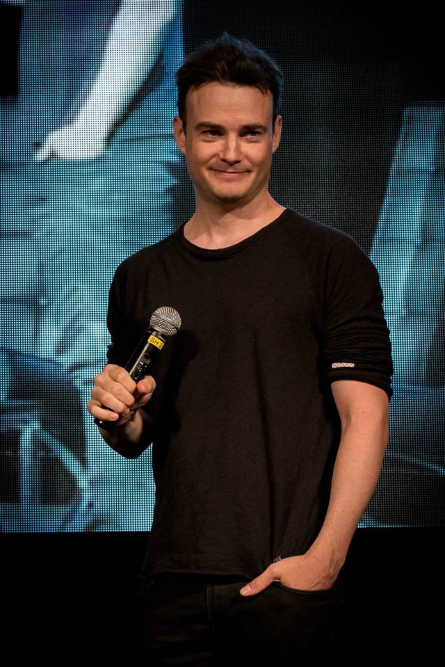 Man holding microphone smiling camera free wallpaper - medium preview image