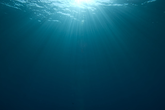 Person riding surfboard underwater sunbeam free wallpaper - medium preview image