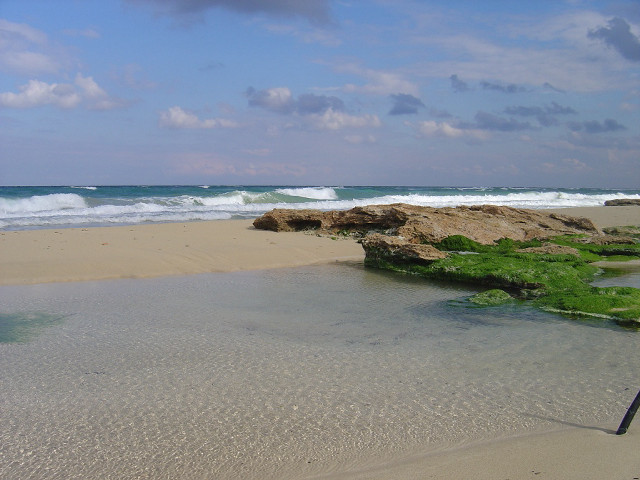 Sandy beach rock outcropping waves free wallpaper - medium preview image