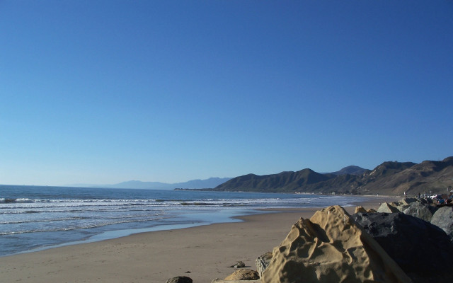 Beach rock formation ocean mountains free wallpaper - medium preview image