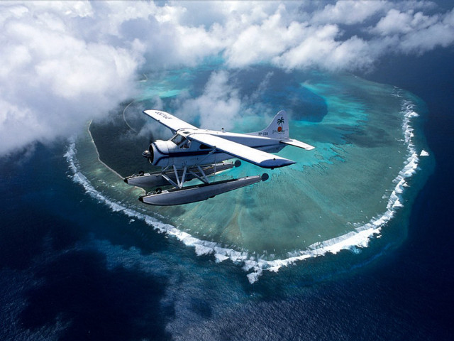 Plane flying small island ocean free wallpaper - medium preview image
