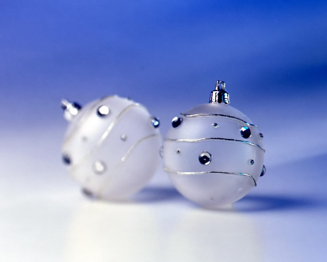 Two white ornaments sitting on free wallpaper - medium preview image