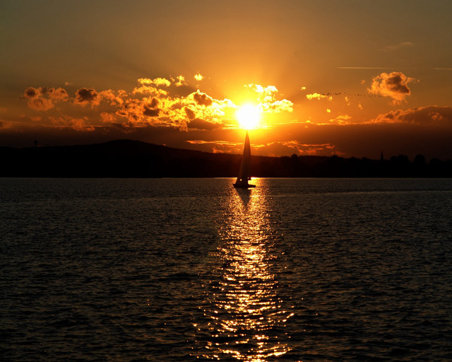 Sailboat sunset mountains clouds water free wallpaper - medium preview image