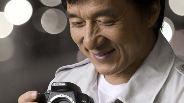 Man holding camera smiling blurry free wallpaper - medium preview image