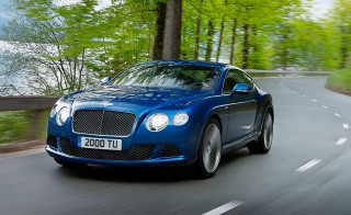 Blue bentley driving road forest - a lake in the background free wallpaper