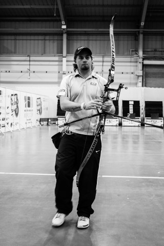 Man holding bow arrow building - free portrait wallpaper