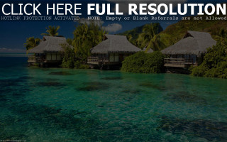 Huts hillside ocean lush green - a caption free wallpaper