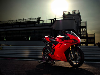 Red motorcycle parked building night - the sun shining behind free wallpaper