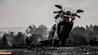 Motorcycle parked rocky road trees - a foggy sky in the background free wallpaper