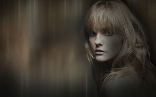 Blonde woman serious look standing - a wall free wallpaper