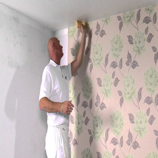 Man painting wall roller brush - a wall free wallpaper