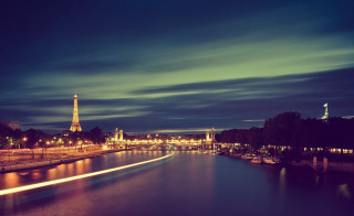 River bridge tower night lights - the water and a boat in the foreground free wallpaper