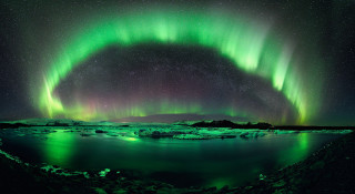 Green purple aurora water icebergs - the background and a mountain range in the distance free wallpaper