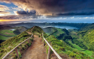 Path mountain top valley cloudy 2 - a view of a valley and mountains free wallpaper