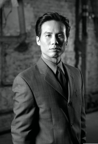 Man in suit black white - a brick wall behind free wallpaper