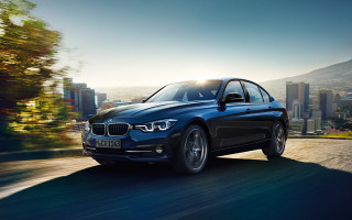 Blue bmw car city street - a city skyline in the background free wallpaper