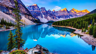 Lake surrounded by mountains trees - a blue sky and water free wallpaper