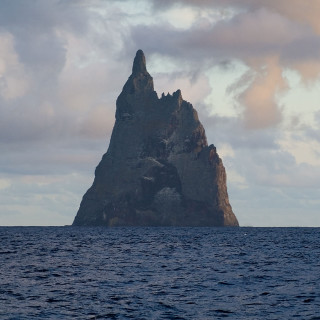 Large rock ocean cloudy sky - a boat free wallpaper
