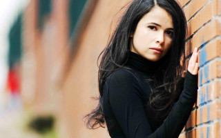 Woman brick wall serious look 2 - against free wallpaper
