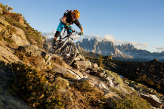 Man bike rocky hillside mountain - a mountain range in the background free wallpaper