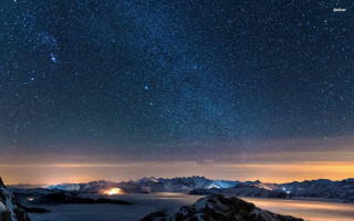 Night sky stars mountains lake - a bright light in the middle free wallpaper