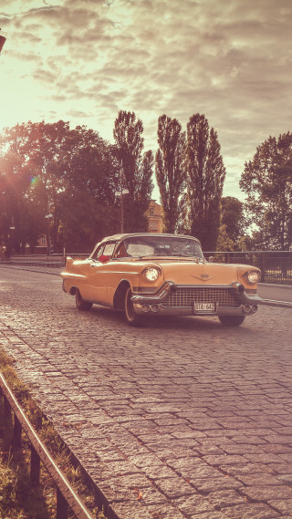 Car parked cobblestone road fence - cinematic photography free wallpaper