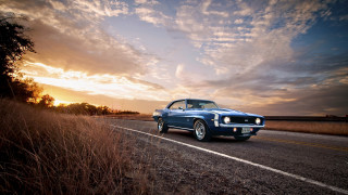 Blue car driving road cloudy - a sunbeam in the background free wallpaper