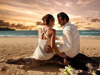 Man woman sitting log beach 3 - romantic free wallpaper