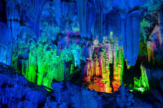 Cave people colorful lights standing - a cave free wallpaper