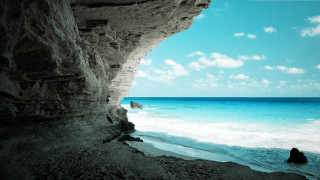 Person rock ocean cliff blue 2 - sense of depth free wallpaper