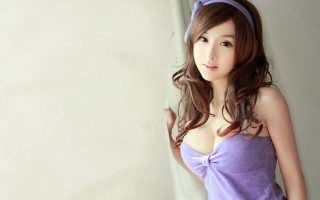 Purple dress woman posing white - a white wall behind her free wallpaper