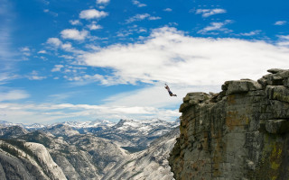 Bird flying rocky mountains blue - a mountain range in the background free wallpaper
