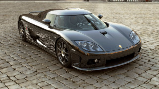 Black sports car cobblestone street - a red fire hydrant free wallpaper