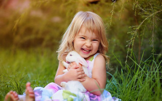 Little girl holding bunny smiling - a bunny free wallpaper