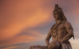 Statue man sitting rock sky - a statue of a man free wallpaper